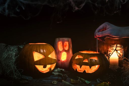 A closeup of decorated Halloween pumpkin head jacks with candles