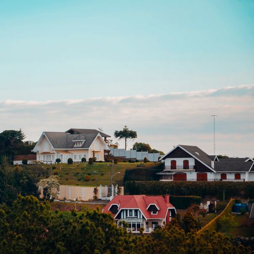 A European styled village with colorful houses surrounded by greenery under a cloudy sky in Brasil