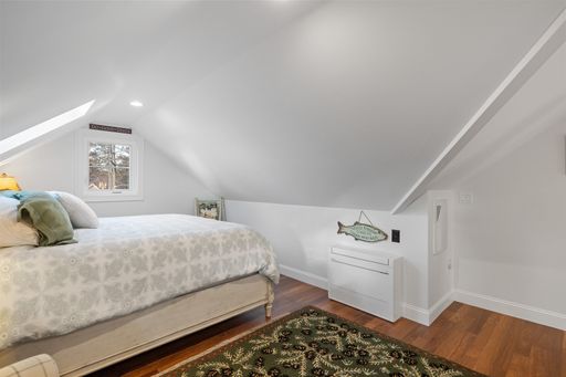 A beautiful light bedroom with a comfortable bed and a small window against the white walls