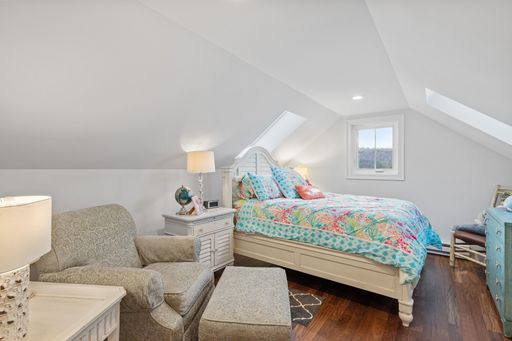 A beautiful light bedroom with a comfortable bed and a sofa against the white walls