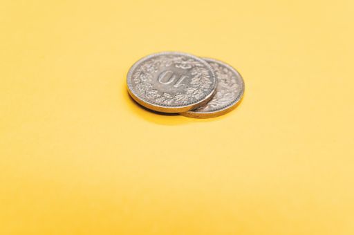 A high angle shot of two coins on an orange surface