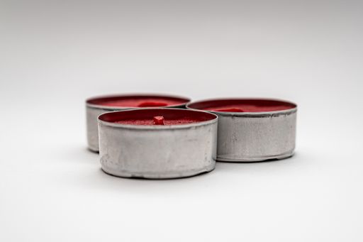 A closeup shot of small decorative red candles in metal cases isolated on a white background