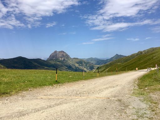 A narrow road leading to high rocky mountains in the highlands