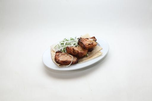 A high angle shot of pork in a white plate on a white background