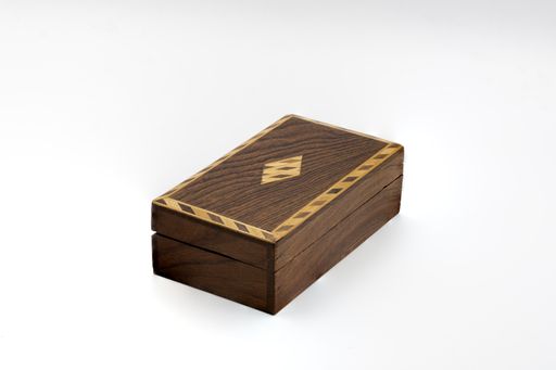 A closeup shot of a closed dark wooden long box isolated on a white background