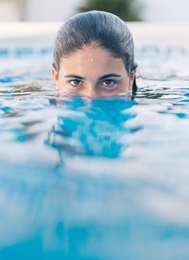 A vertical shot of a young lady in the water