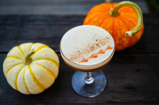 A high angle shot of a refreshing pumpkin-flavored drink on a black surface
