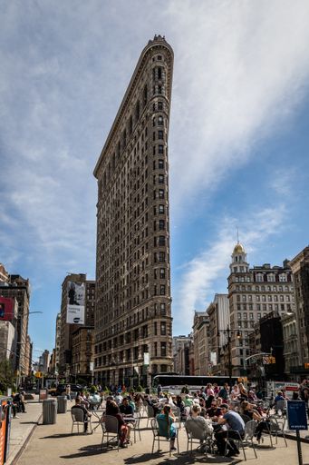 The Flatiron in New York city with tourists enjoying the sun