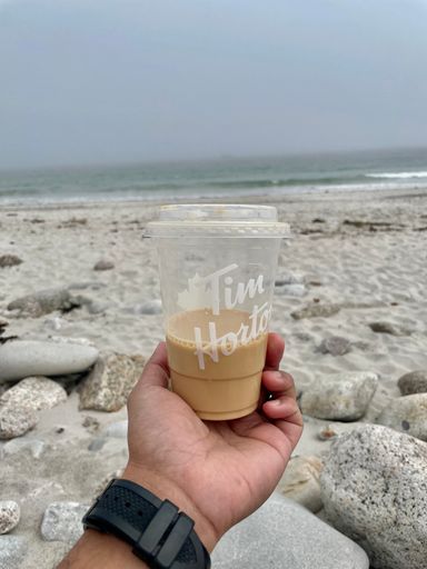 A closeup of chilled Tim Horton's iced coffee by the Crystal crescent beach