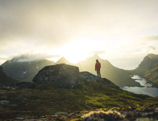 A male admiring the sunset while standing in the mountains of Veinestinden in Lofoten Islands