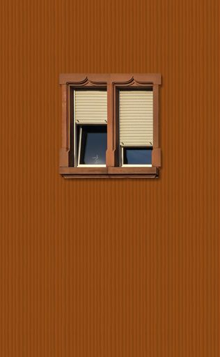 A vertical shot of beautiful windows of a brown building