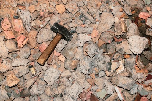 A top view shot of a hammer on the rubble of rocks used in demolition