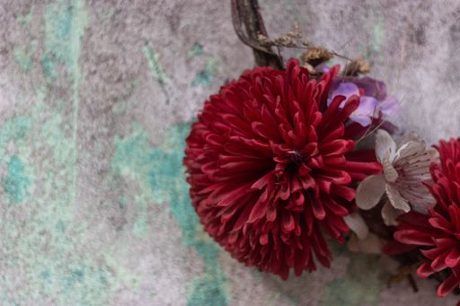 A high angle closeup shot of beautiful flowers on a floral headband with a stone background