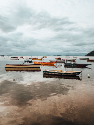 A beautiful landscape shot of the boats and the beach during the sunset in Rio de Janeiro.