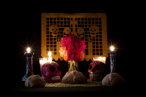 Mini altar for the day of the dead in Mexico with candles, colored skulls, and flowers