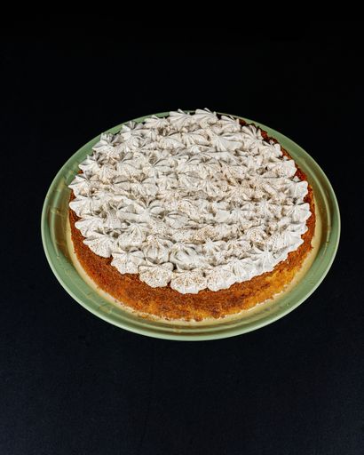 A vertical shot of a delicious cinnamon cake placed on a dark surface