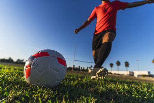 A soccer player hitting the ball, the concept of a healthy sporty lifestyle