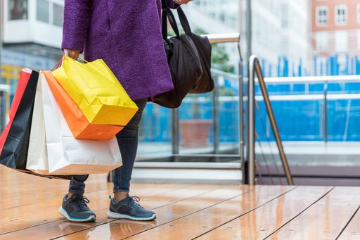 A closeup shot of a female carrying shopping paper bags