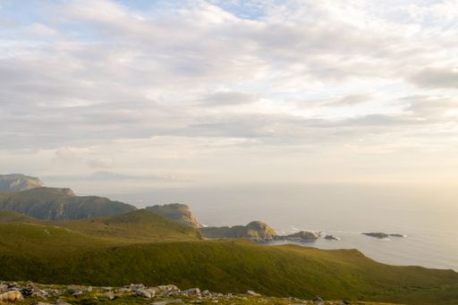 A beautiful view of green beach by the shiny sea under gray sunset sky