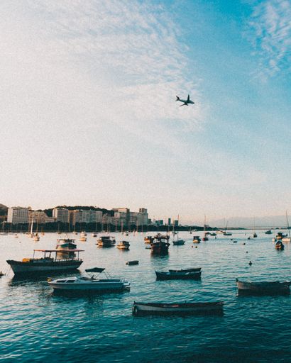 Sunset in Urca, Rio de Janeiro, with boats and a plane landing in Rio de Janeiro airport