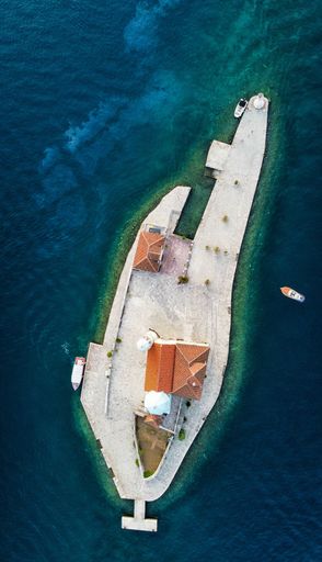 A vertical aerial view of the island of the Church of Our Lady of the rocks in Kotor Bay, Montenegro