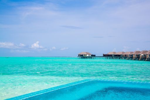 A long empty jetty in the Maldives with coral reefs in the water
