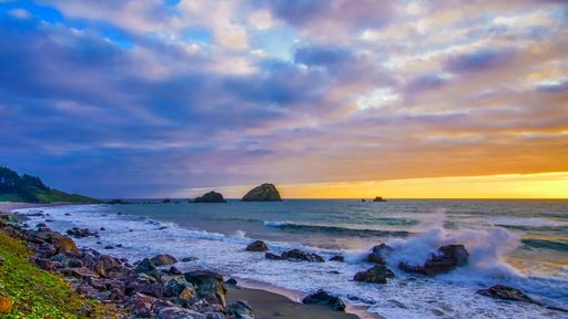 A breathtaking shot of the sun rising over the ocean under the cloudy sky