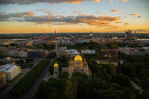 A beautiful sunset over the city of Riga with a cathedral in the middle