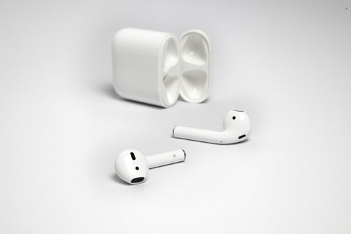A closeup shot of white wireless headphones with their case on white background