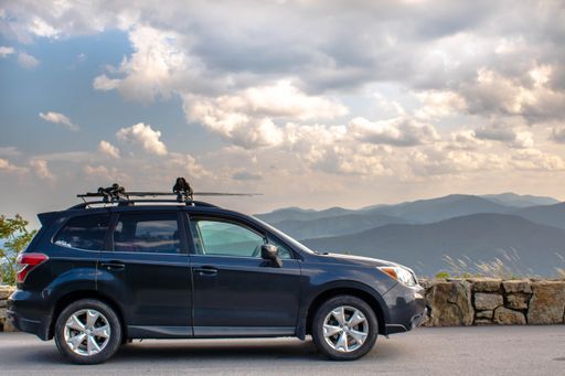 A subaru forester Suv parked in the Shenendoah national park against a skyline of mountain and clouds
