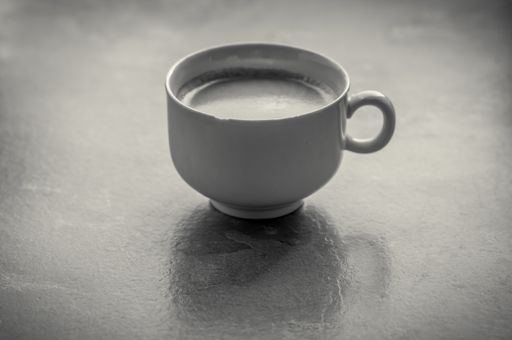 A grayscale high angle shot of a coffee mug