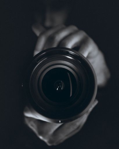 A vertical shot of a person holding a professional camera