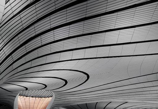 An artistic architectural wave design on the ceiling of a modern building