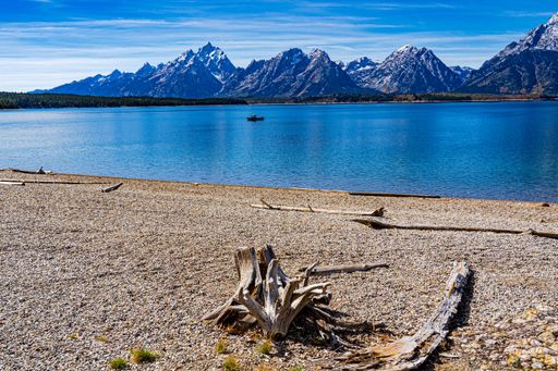 The image shows a beach on Jackson Lake in Grand Teton National Park with a view of the mountains in the distance