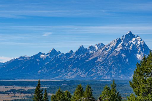 The image shows a view of the highest mountain in the Range, Grand Teton, and some of the other mountains in the Park