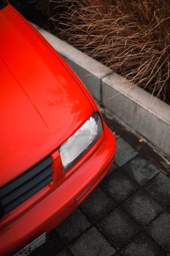 A vertical closeup shot of details on the red car