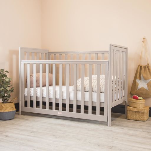 A modern baby room interior with a cozy classic crib with some decorative accessories on sides