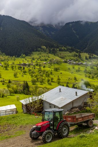 A vertical shot of the beautiful village and a tractor captured in Switzerland
