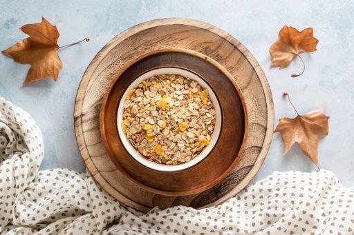 A topview of muesli in wooden plates  with autumn leaves