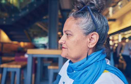 A portrait of an old stylish woman sitting in a restaurant