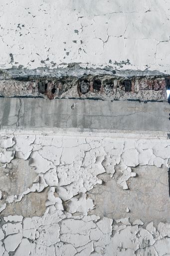 A vertical shot of an old wall with the paint peeling off it