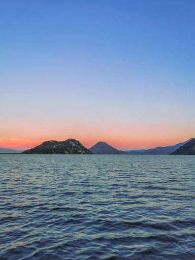 A vertical shot of a bright blue orange sunset sky over a seashore