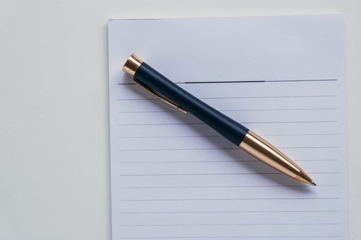 A top view of ballpen and paper on a table with copy space