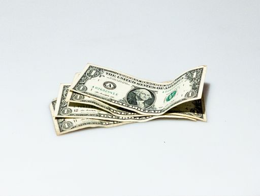 An isolated shot of a few one-dollar bills on a white background