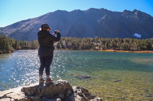 A woman takes landscape photos on her phone in the Virginia Lakes area.