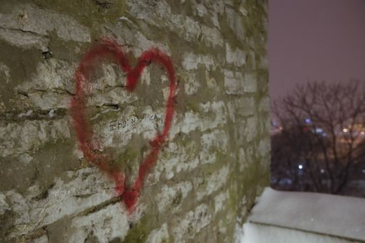 Limestone brick wall with the heart shape graffiti on the winter night old Tallinn, Estonia