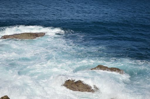 The sea surrounded by rocks under the sunlight at daytime - perfect for wallpapers