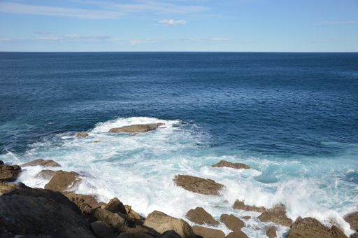 The sea surrounded by rocks under the sunlight at daytime - perfect for wallpapers