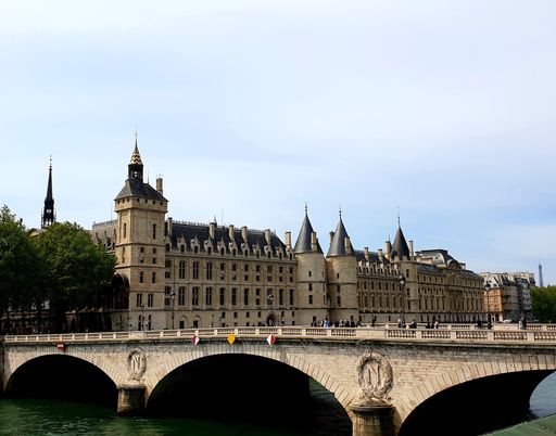 The Conciergerie Palace and Bridge of Change over the River Seine, full of visitors on a sunny day