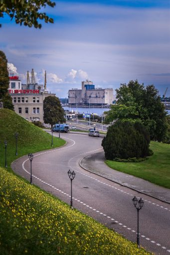 A vertical shot of a road in Szczecin, Poland, with the Szczecin Port building in the background